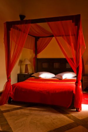 طراحی تخت خوابی با تور های قرمز هم فضایی رمانتیک ساخته
