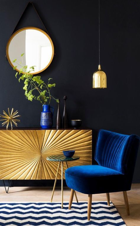 هارمونی زیبای رنگ طلایی را بین میز کنسول، المان روی آن، آینه و لوستر نشان می دهد.